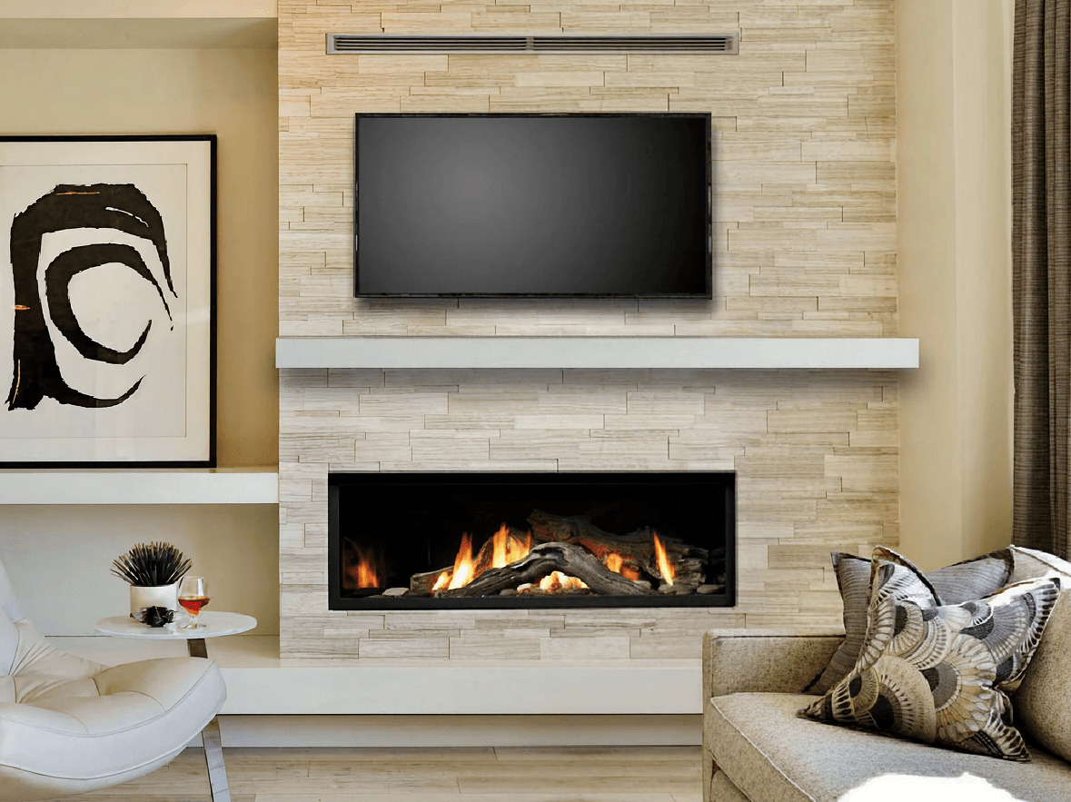 Modern living room with a beige stone fireplace below a flat-screen TV. Abstract black-and-white art, cozy chair, and a small table with decor create a warm ambiance.
